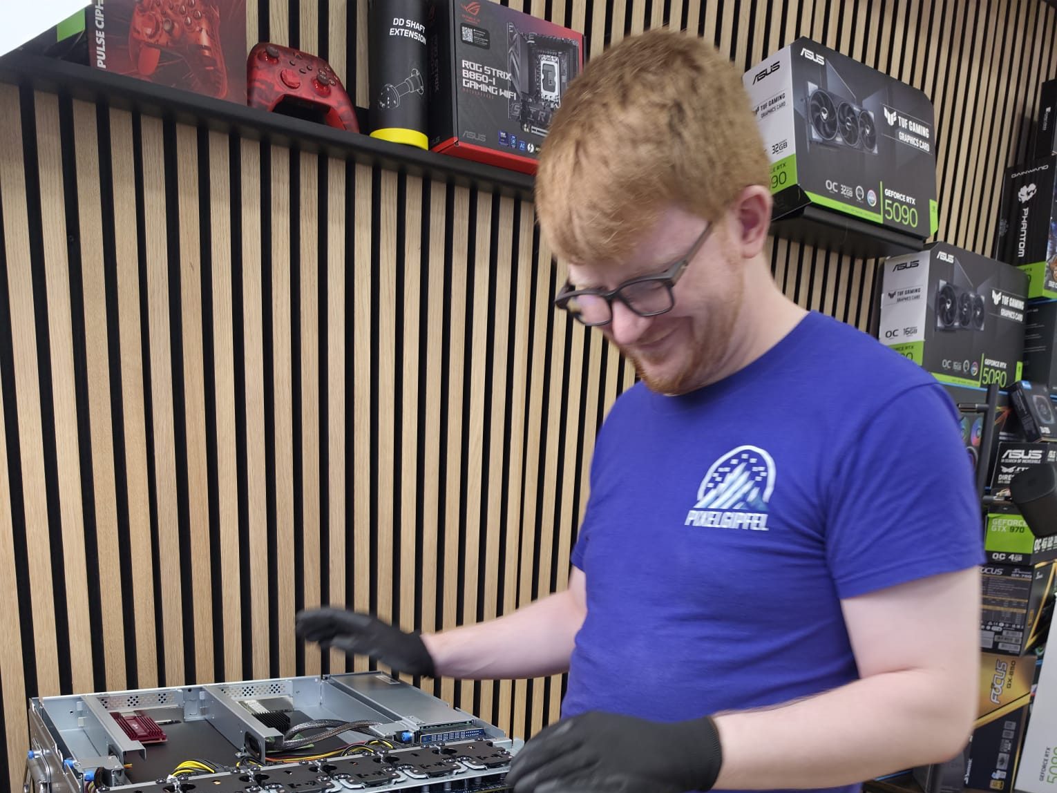 Lukas von Pixelgipfel arbeitet mit Handschuhen an einem geöffneten KI-Server